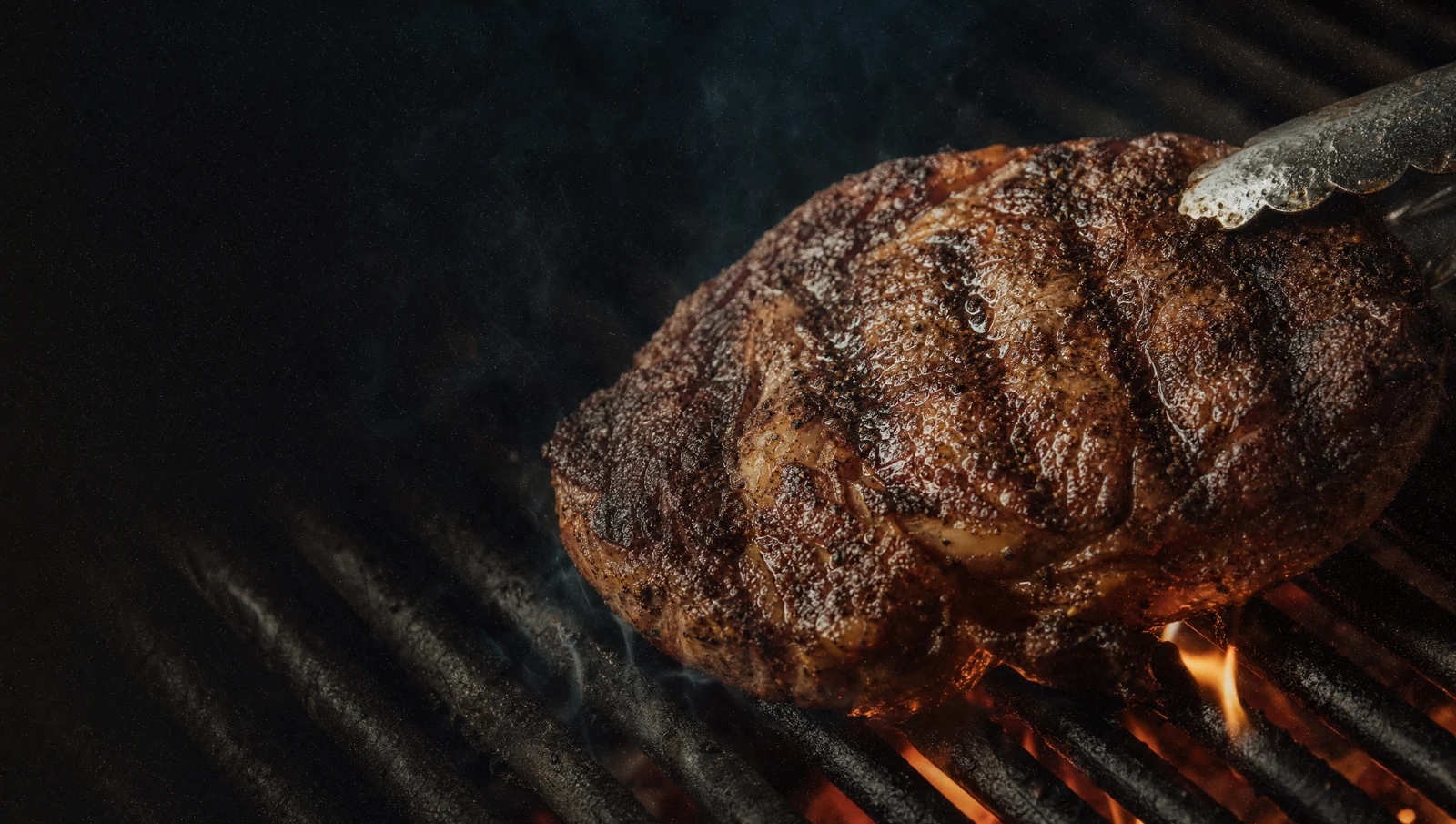Steak cooking over an open grill
